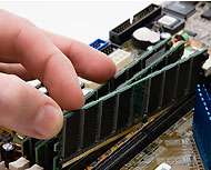 A person installing RAM into a computer